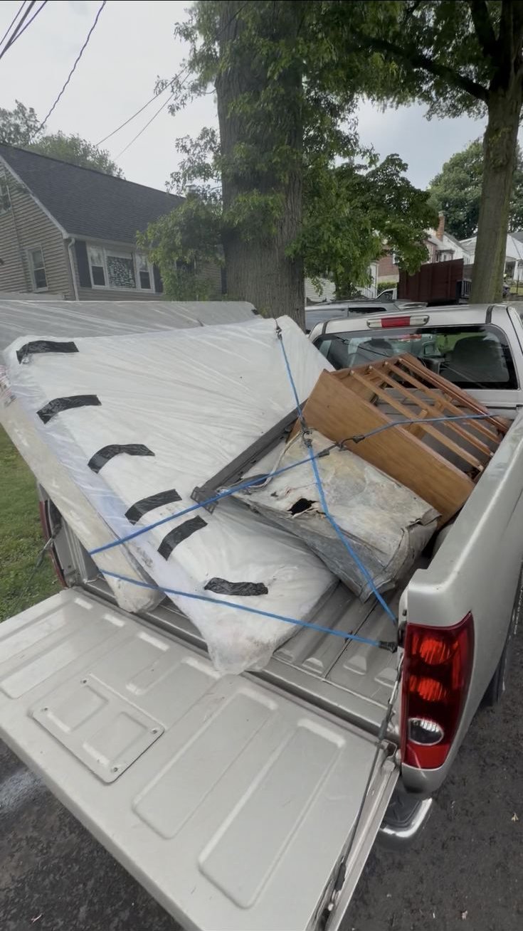 Mattress and box spring loaded in a truck bed for removal