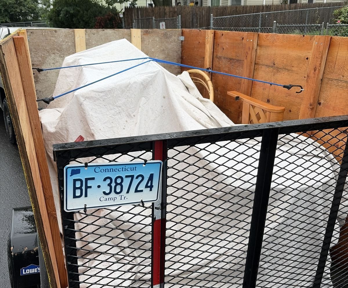 Gold Coast Junk Removal trailer loaded with covered furniture